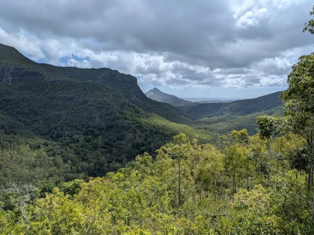 Vue sur la chaine de montagnes et la forêt du parc naturel des Gorges de Rivière Noire à l'Île Maurice avec en arrière plan le lagon
